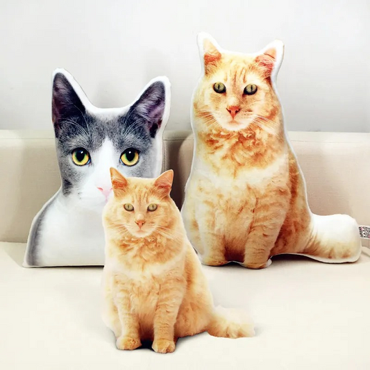 Three cat-shaped cushions on a white surface with a light gray background