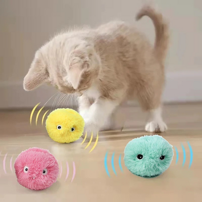 Cat playing with three colorful plush toys on a wooden floor.