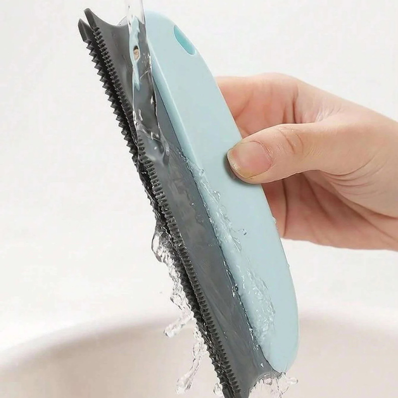 Hand holding a blue grooming tool with water splashing around it on a white background