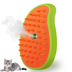 Pet grooming brush with orange bristles and green handle next to a cat on a white background