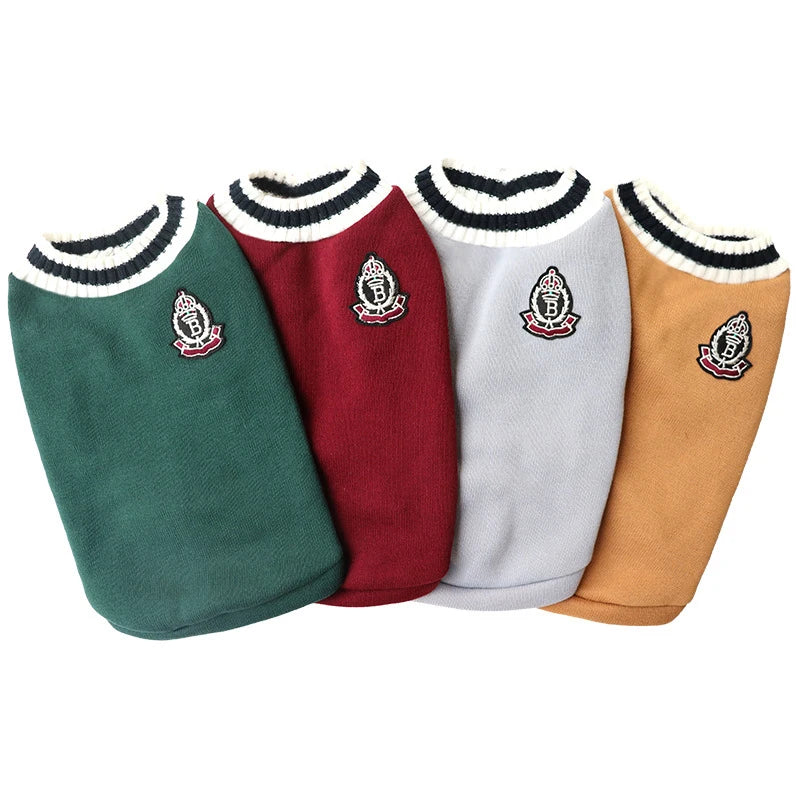 Four dog sweaters in green, red, gray, and brown with embroidered logos on a white background.