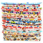 Stack of colorful fabric strips with various patterns on a white background