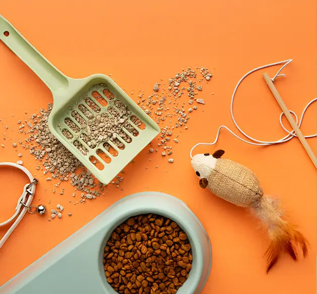Pet care products including a scoop, food bowl, and toy on an orange background